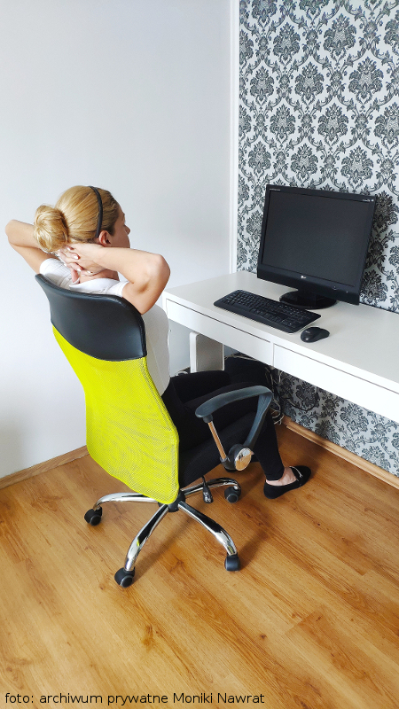 Zdjęcie obrazuje wykonanie ćwiczenia nr 3: nasz ekspert - Monika siedzi wyprostowana przed biurkiem i naciska głową na dłonie splecione na karku.