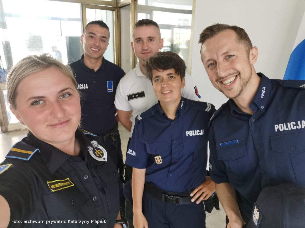Zdjęcie wykonano w budynku. Polska policjantka i polski policjant stoją w otoczeniu funkcjonariuszy z Chorwacji, Bośni i Hercegowiny oraz Słowacji. 